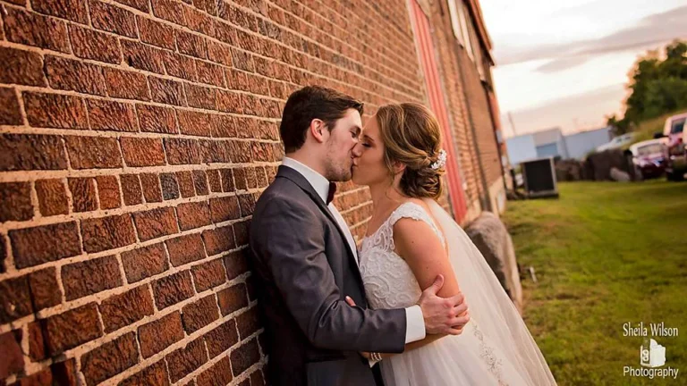 Bride and groom against the weathered brick of the Gallatin depot