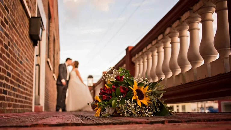 Bride and groom on the depot's front porch at golden hour